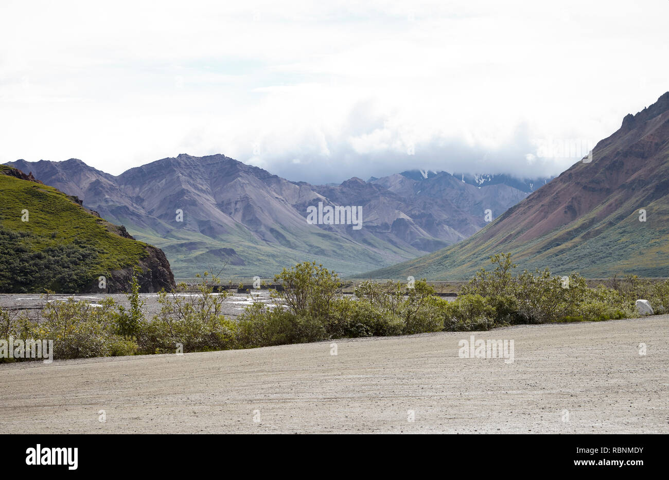Letto asciutto del fiume in esecuzione attraverso la valle tra le montagne in Alaska Foto Stock