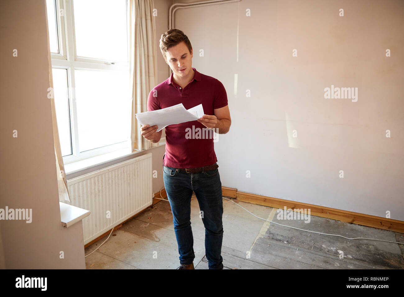 Voce maschile primo acquirente di tempo guardando House sondaggio nella stanza che deve essere rinnovato Foto Stock