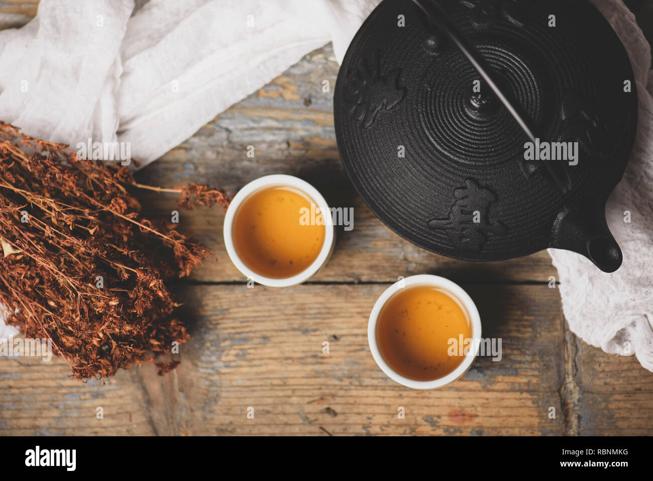 Ghisa giapponese teiera con foglie di tè e tazze su un handmade tappetino  di granturco Foto stock - Alamy