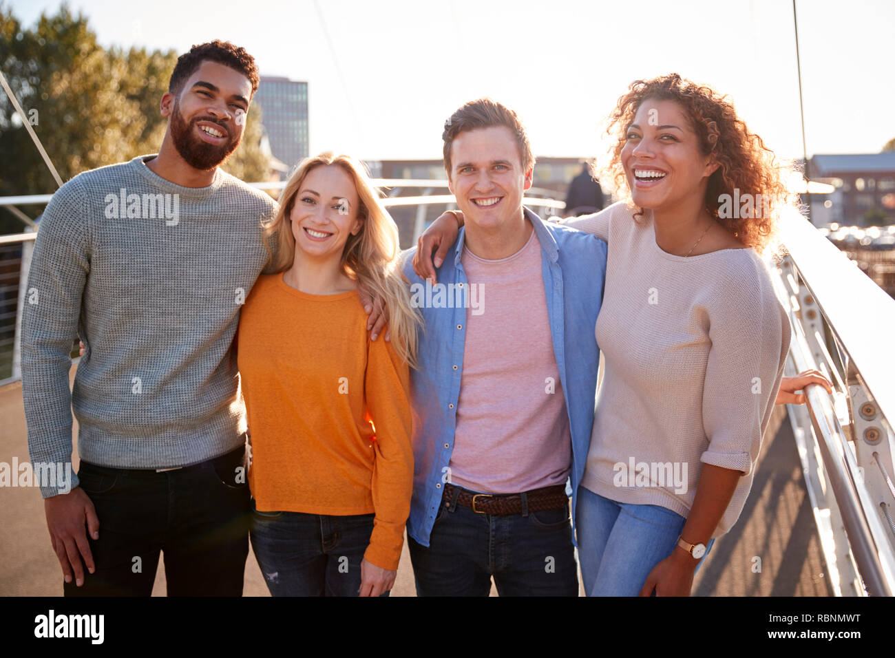 Ritratto di giovani amici attraversando a piedi il ponte della città insieme Foto Stock