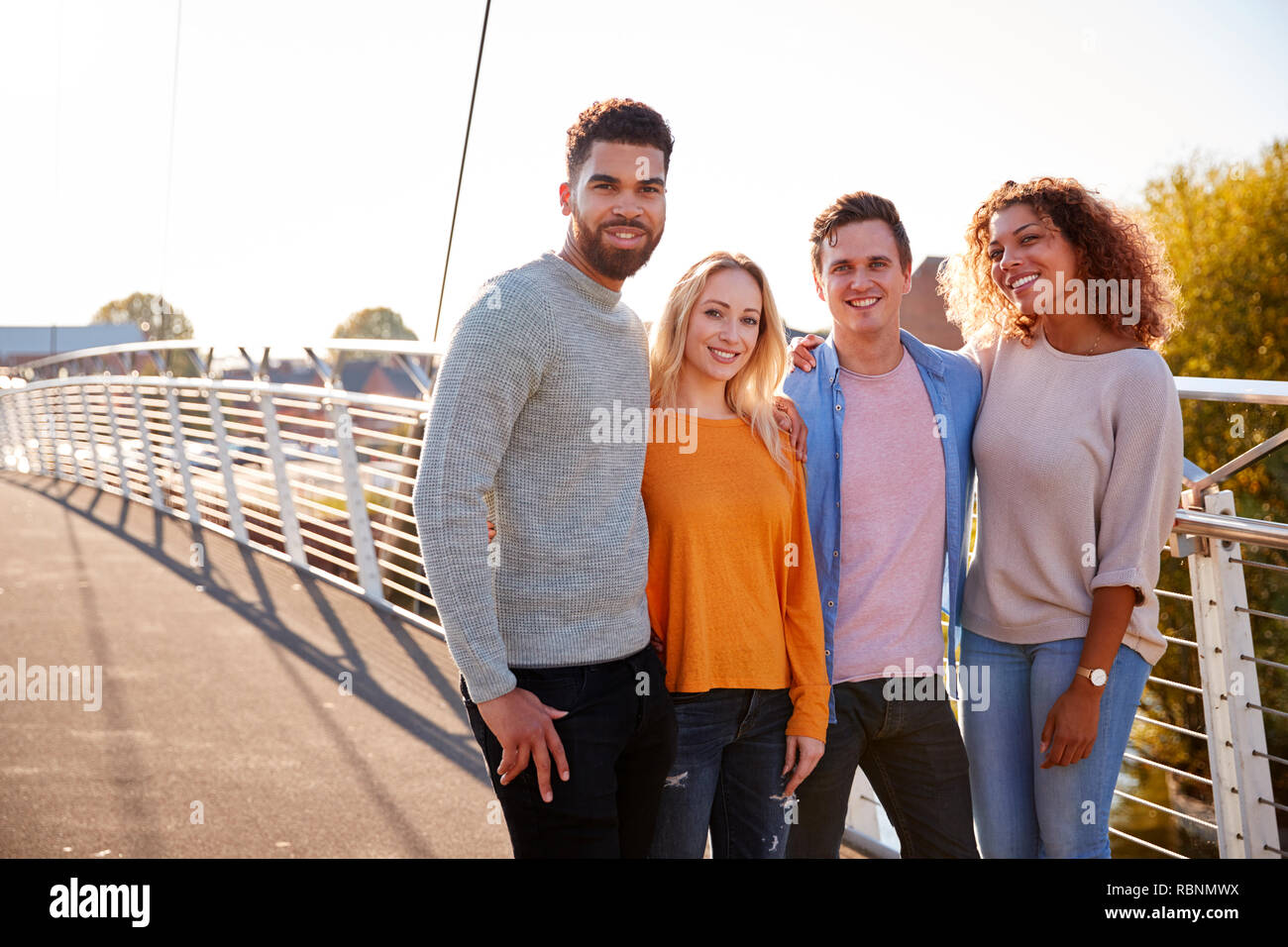 Ritratto di giovani amici attraversando a piedi il ponte della città insieme Foto Stock