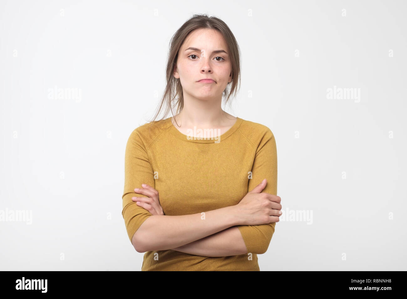 Grave giovane femmina rosso da indossare pulover guardando la telecamera e i suoi occhi pieni di sfiducia e di disappoinment come ella ha litigare con il mio ragazzo Foto Stock