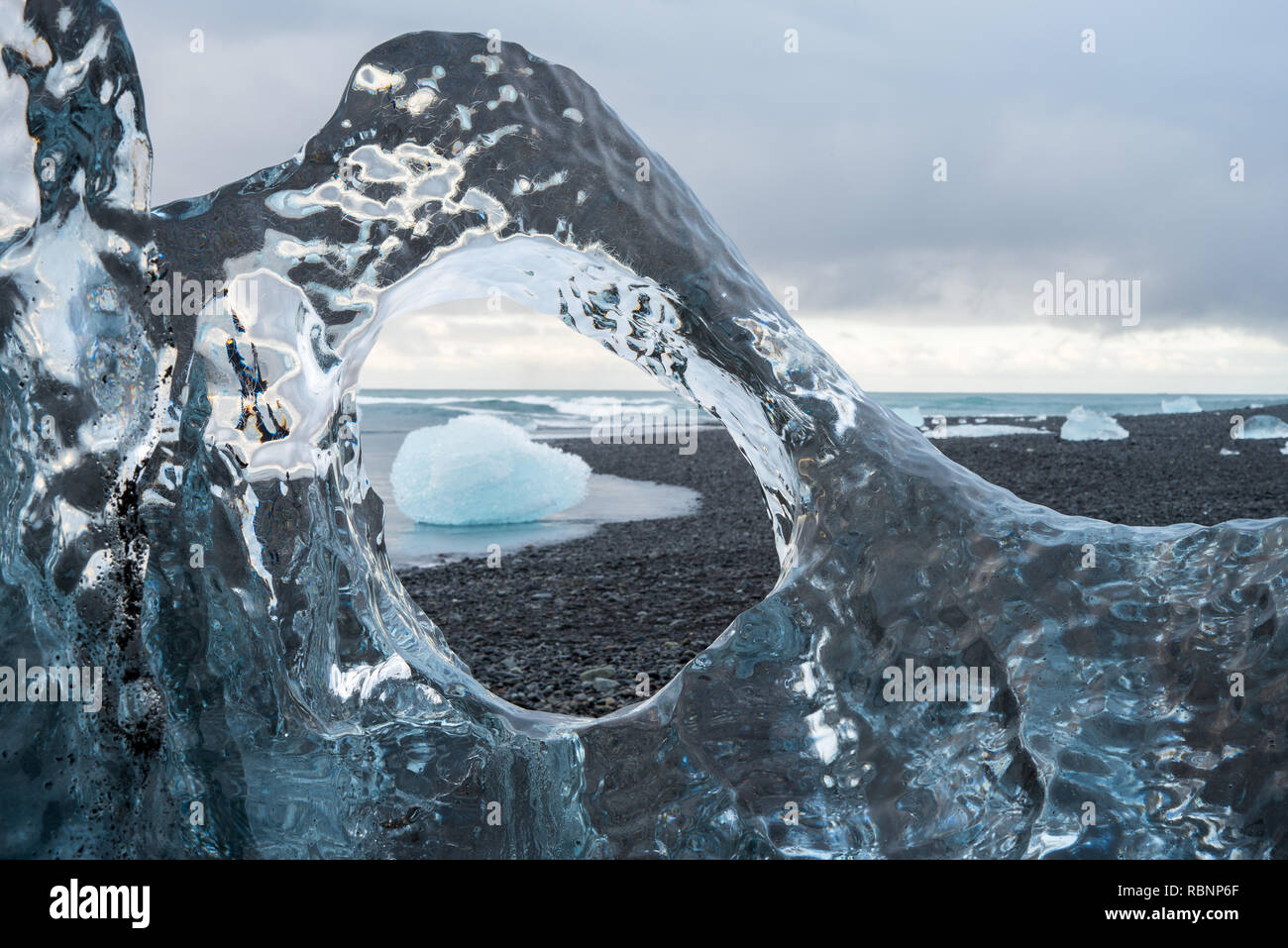 Vista attraverso una finestra di un iceberg trasparente all'oceano Foto Stock