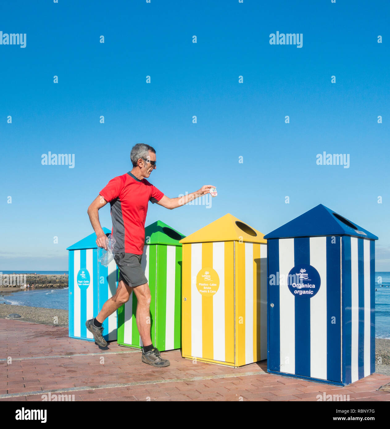 Pareggiatore maturo/plogger raccogliere spazzatura come egli corre. Foto Stock