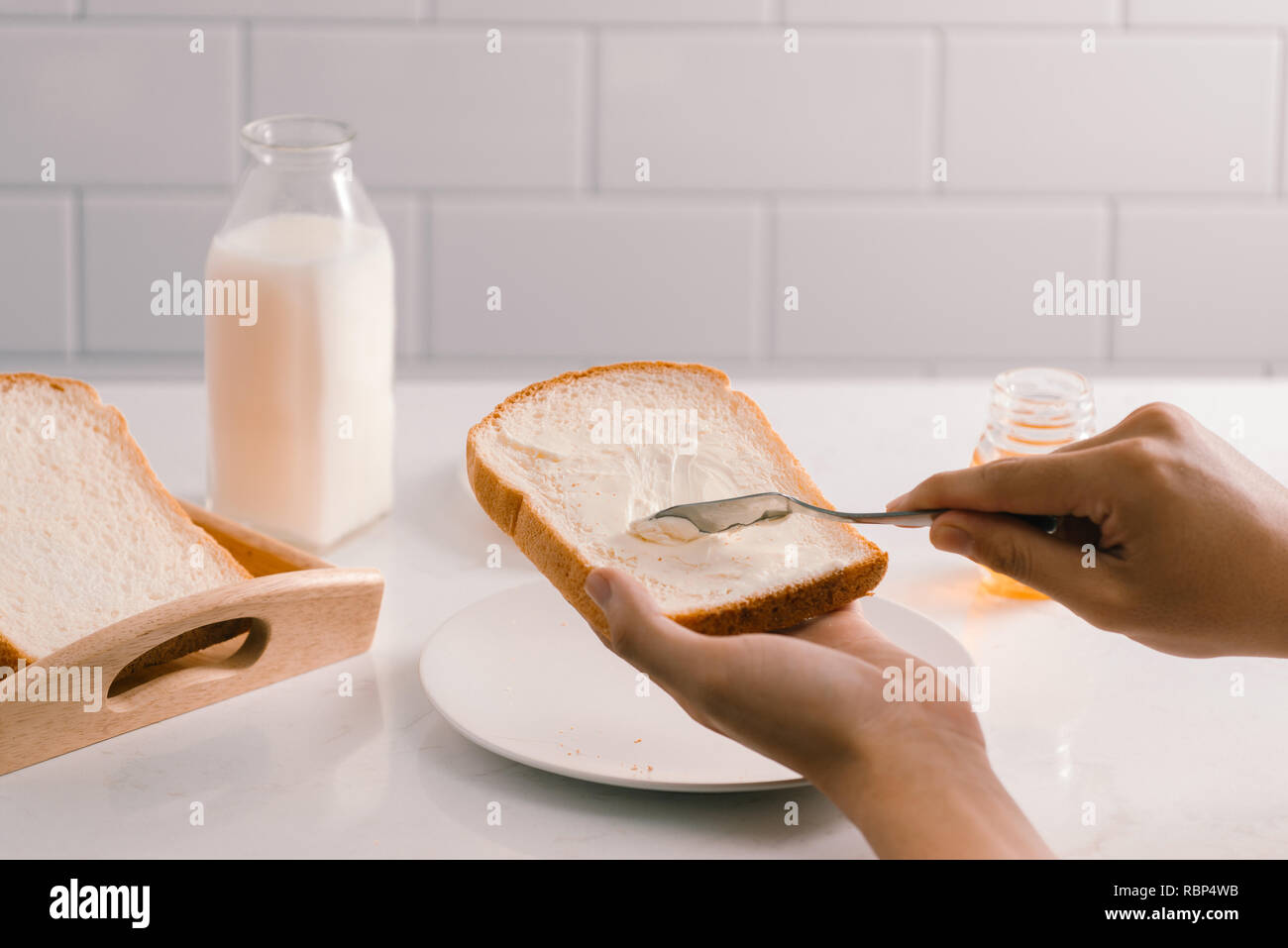 L'uomo diffondere il burro sulla fetta di pane, primo piano Foto Stock