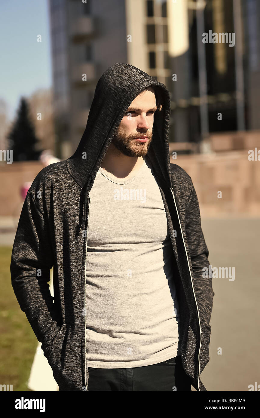 L'uomo sport fashion, barbuto ragazzo modello in felpa con cappuccio nero o  di jersey e di camicia esterna di sole su sfondo sfocato Foto stock - Alamy