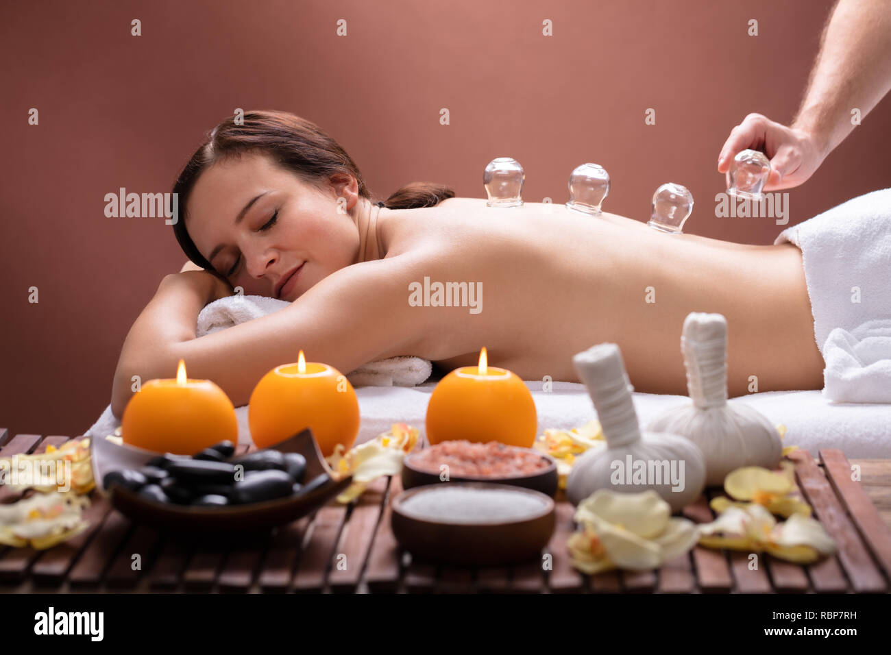 Rilassata giovane donna ricevere trattamento Cupping sulla sua schiena In Spa Foto Stock