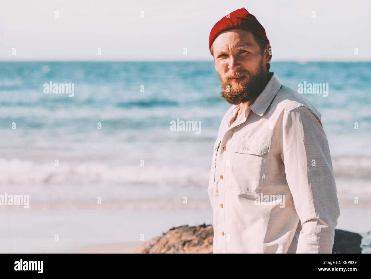Bello barba uomo a camminare sulla spiaggia dell'oceano estate vacanze viaggi viaggio lifestyle moda avventura esterna Foto Stock