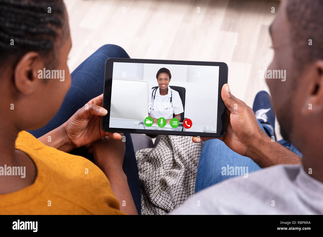 Close-up di un Africano giovane Videoconferenze con felice medico donna sulla tavoletta digitale Foto Stock