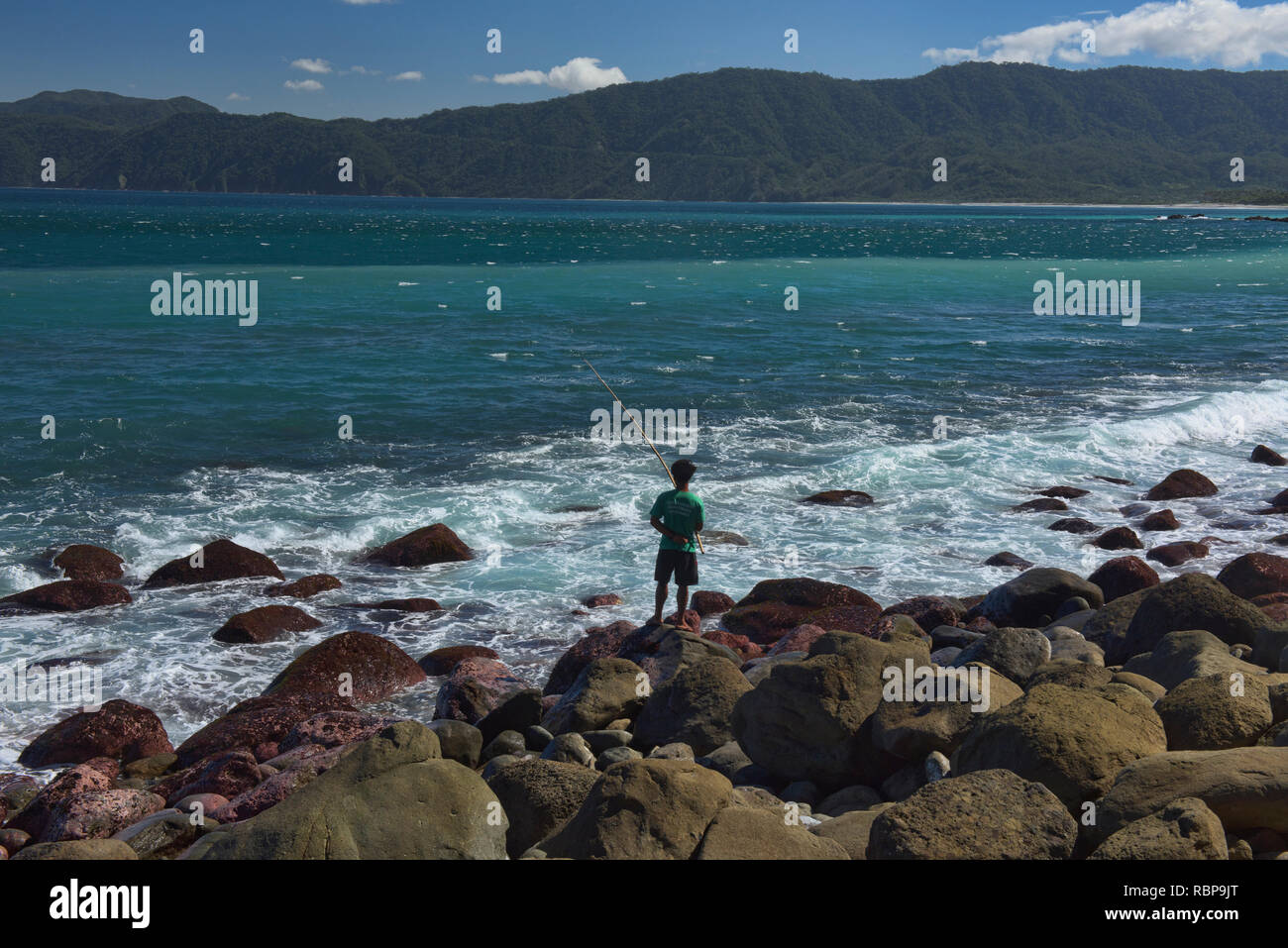 Pescatore sulla costa rocciosa, Pagudpud, Luzon, Filippine Foto Stock