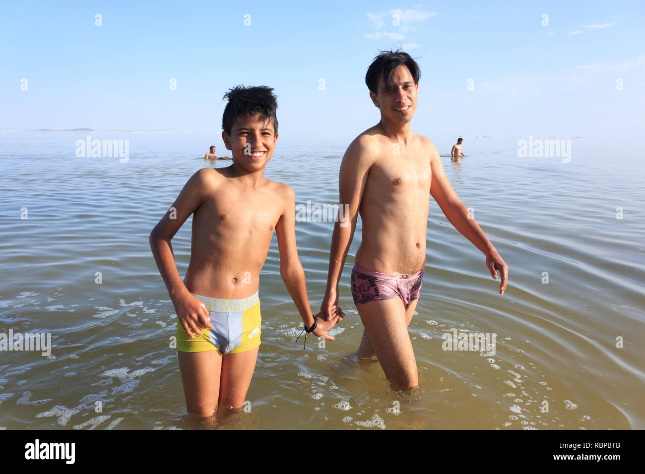 Due fratelli sono camminare e nuotare nel sale Urmia Lake, West Azerbaijan provincia, Iran Foto Stock