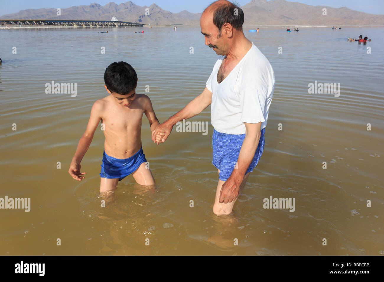 Un nonno con il nipote nel sale Urmia Lake, West Azerbaijan provincia, Iran Foto Stock
