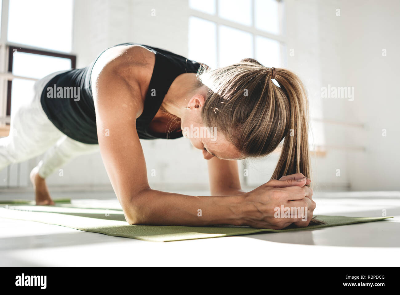 Donna sana fitness ginnastica in ABS bianco in gomma soleggiato. Montare la donna facendo crossfit allenamento sul tappetino Foto Stock