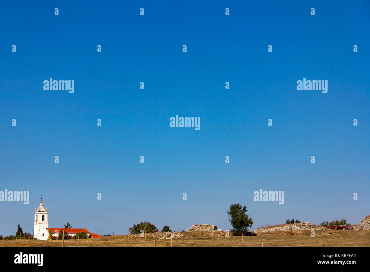 Una chiesa isolata nei pressi di Conimbriga in Portogallo sotto un cielo blu senza nuvole Foto Stock