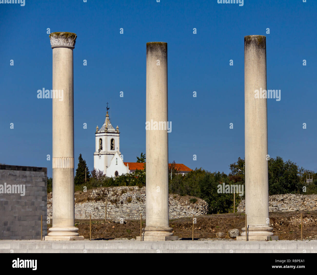 Chiesa incorniciata da colonne romane a Conimbriga in Portogallo sotto un cielo blu senza nuvole Foto Stock