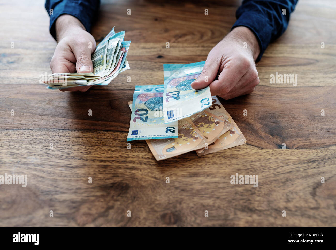 Uomo seduto alla scrivania conteggiare denaro Foto Stock