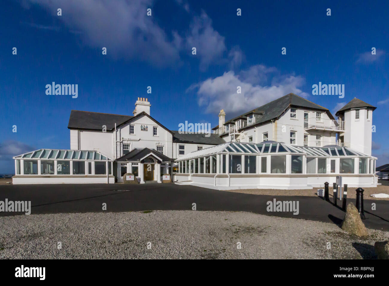 Ristorante e hotel a Lands End in Cornovaglia, Inghilterra sotto un cielo blu con nuvole bianche Foto Stock
