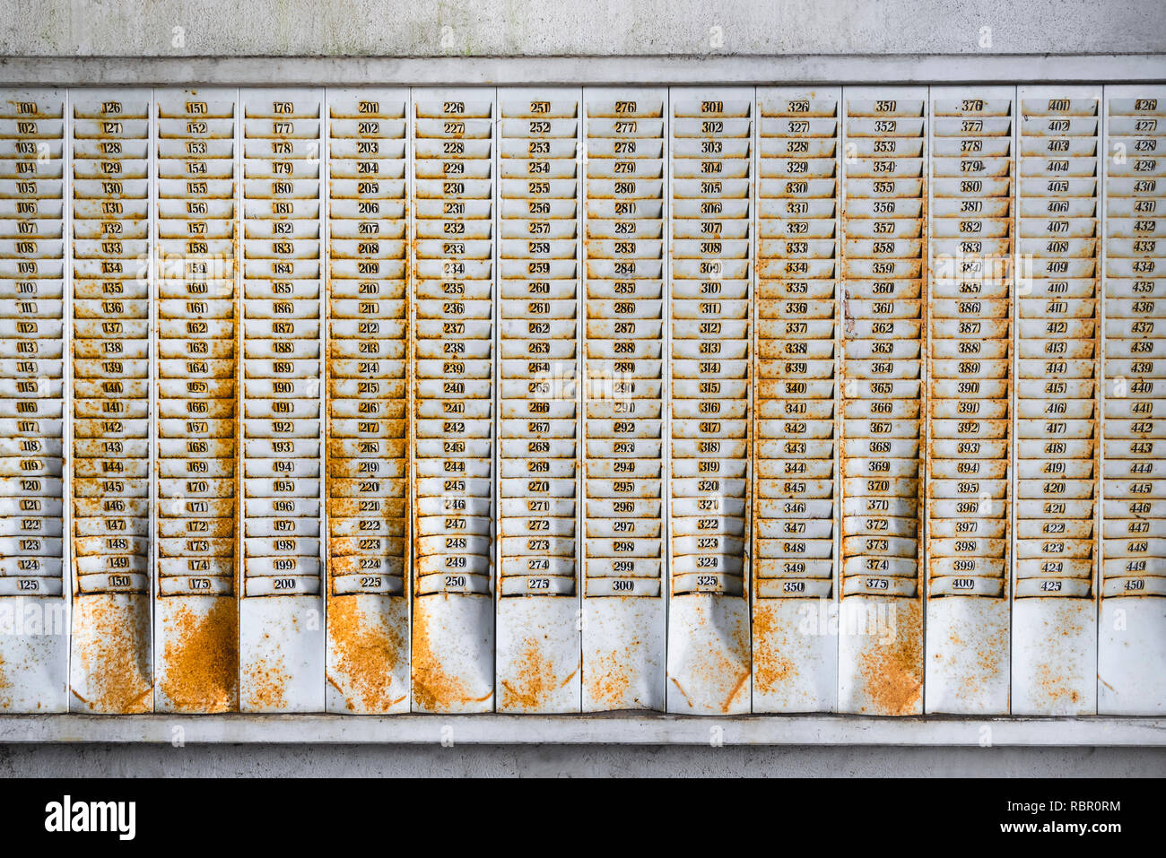 Rusty montaggio a parete con gli alloggiamenti numerati per schede di timbro in una fabbrica abbandonata la costruzione di Foto Stock