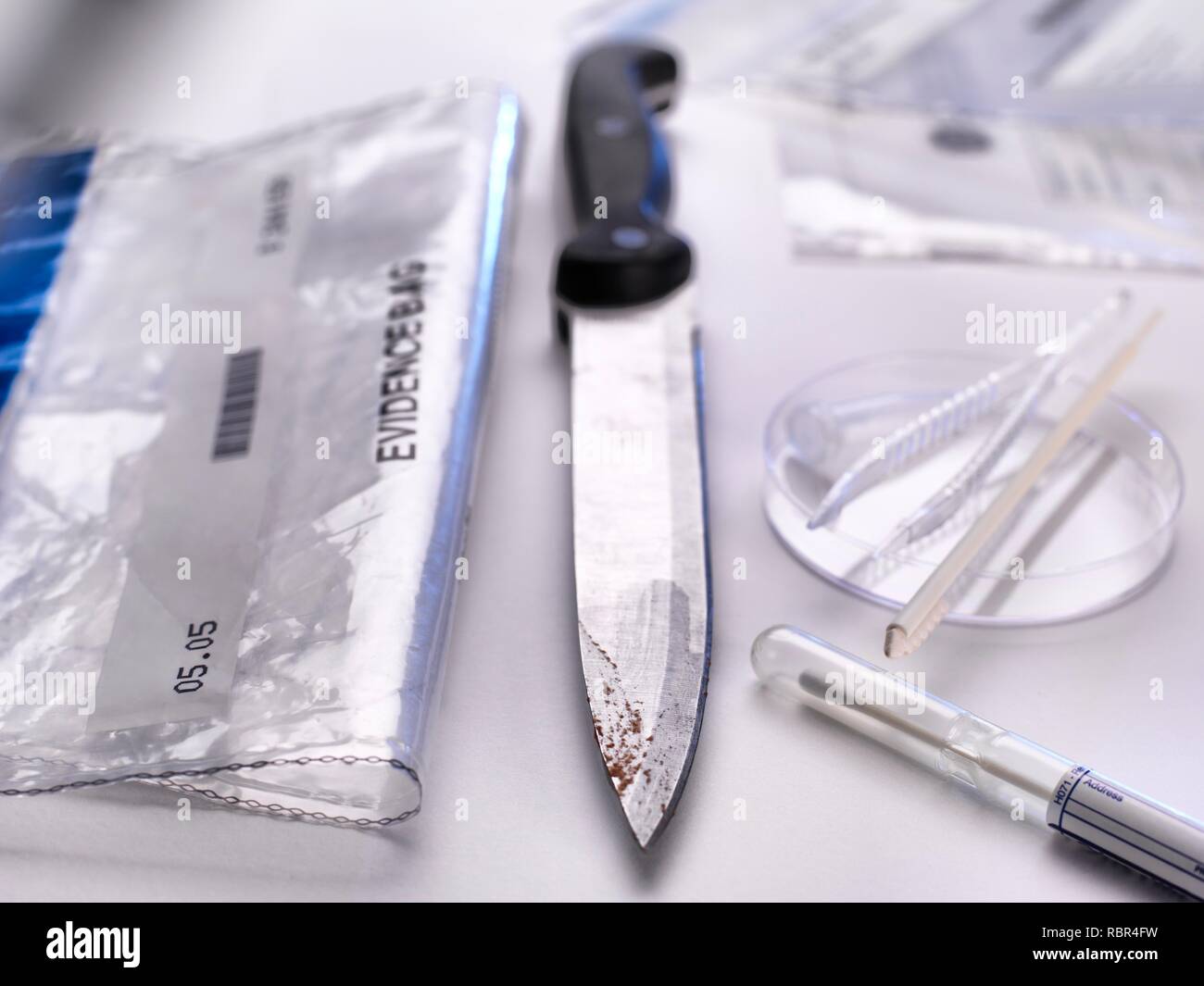 Prove forensi collezione. Un coltello che sta per essere prelevati mediante tampone per DNA (acido desossiribonucleico) e altre prove forensi. Foto Stock