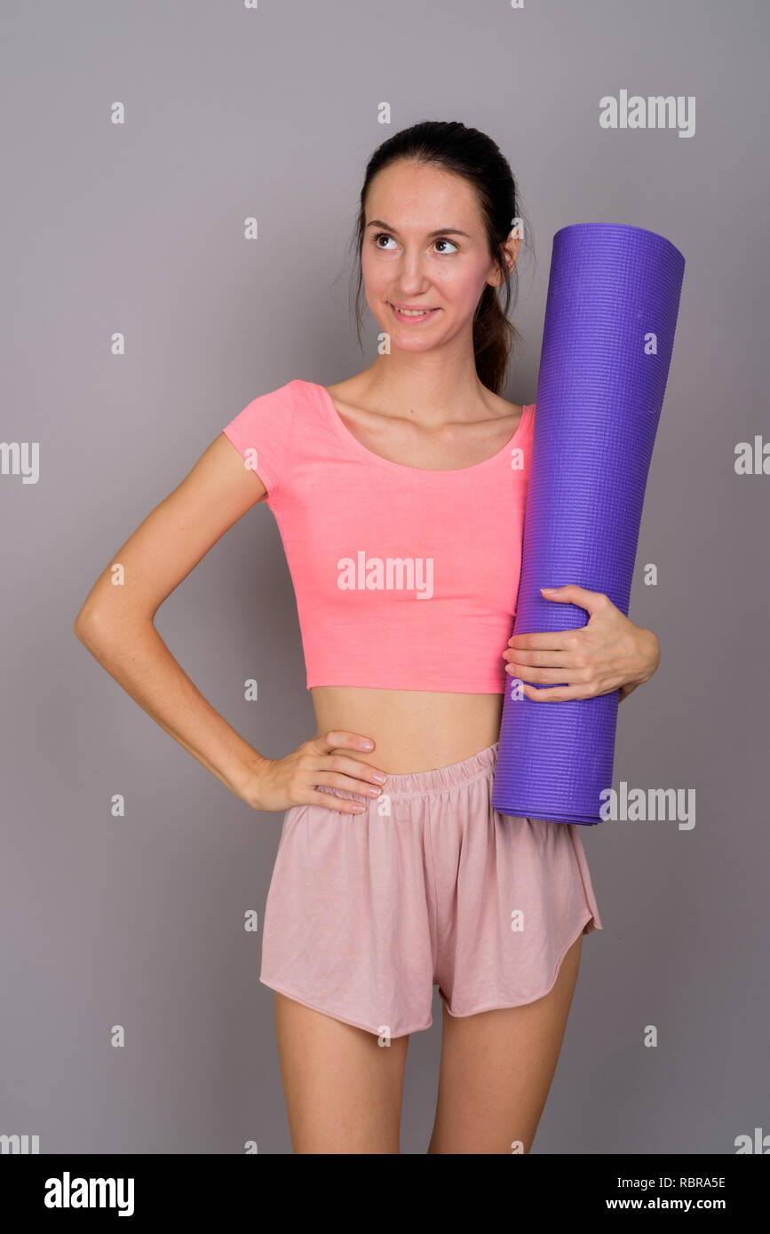 Giovane bella donna pronta per la palestra azienda materassino yoga Foto Stock
