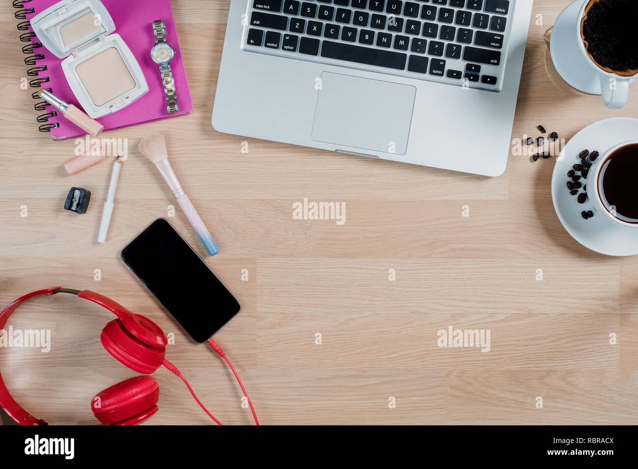 Ufficio tavolo scrivania con computer portatile,caffè,smartphone,cuffia e set cosmetico.Vista dall'alto,laici piatta con copia spazio. Foto Stock