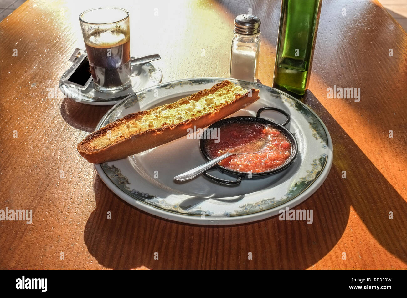 Typcal prima colazione spagnola, caffè e pane tostato con olio di oliva e triturato di pomodoro naturale, tabella Soleggiato al mattino presto Foto Stock