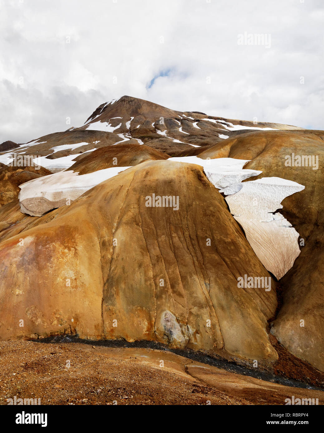 Paesaggio in ocra e toni di marrone con nevai e un piccolo fiume - Location: Islanda, Highlands, area "Kerlingarfjöll' Foto Stock