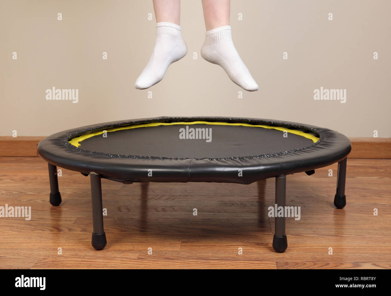 Donna di saltare sul trampolino di piccole dimensioni che mostra i piedi e le gambe inferiori solo Foto Stock