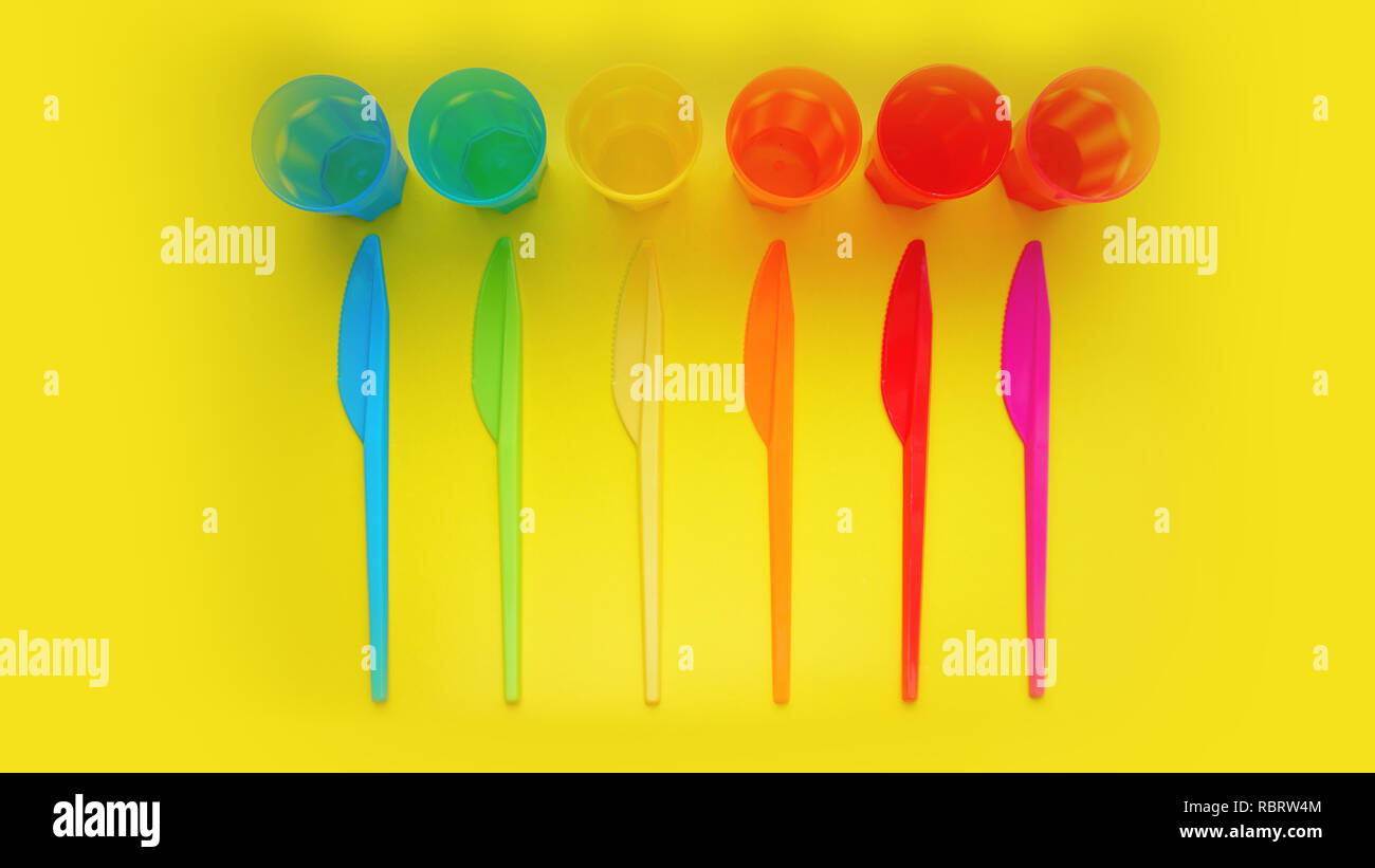 Plastica colorata ware. Oggetti per il servizio da tavola per un picnic fatta di plastica colorata. Coltelli e mug nel set di stoviglie per pic-nic, turismo e qualsiasi viaggio. Yello Foto Stock