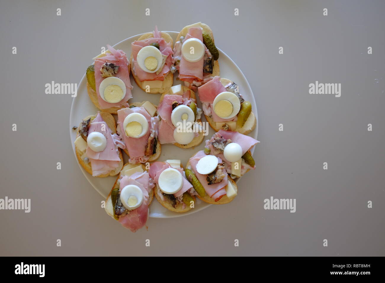 Lato aperto piatto Sandwich sul pane francese con uova sode o prosciutto e guarnire preparate a servire Foto Stock