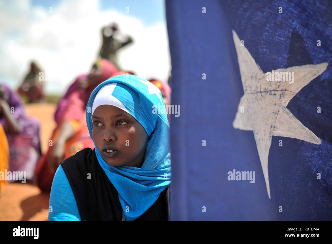 Una giovane donna tiene la bandiera somala durante una dimostrazione di una milizia locale, formato per fornire sicurezza in Marka, Somalia, il 30 aprile. AU ONU FOTO IST - Tobin Jone (14081543544). Foto Stock