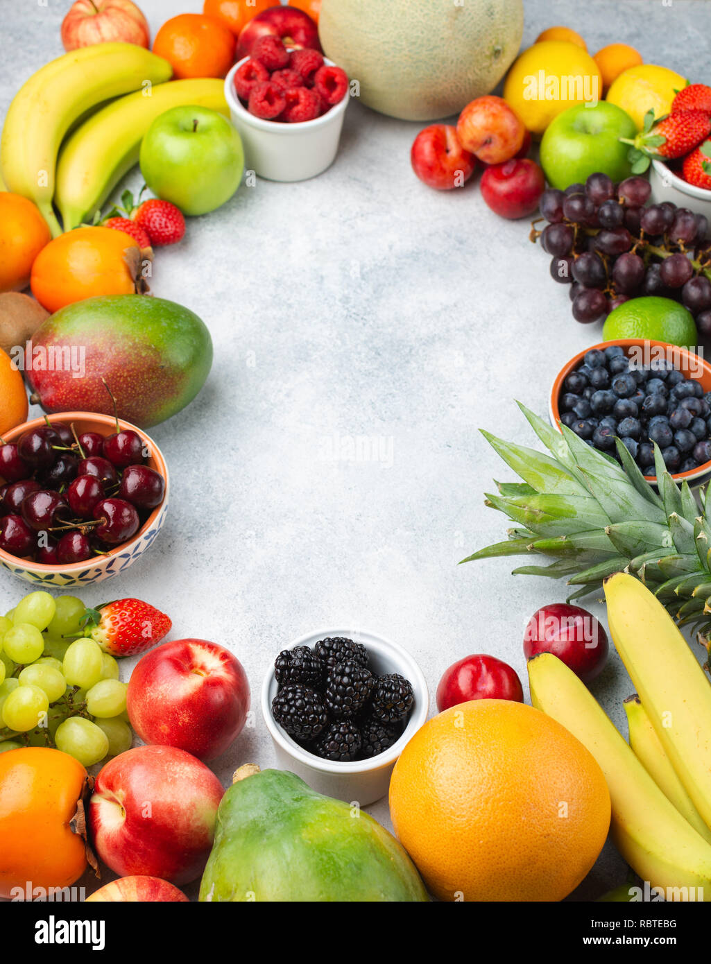 La frutta sana telaio dello sfondo, Fragole Lamponi arance Prugne Mele Kiwi uve mirtilli persimmon mango sul tavolo bianco Foto Stock
