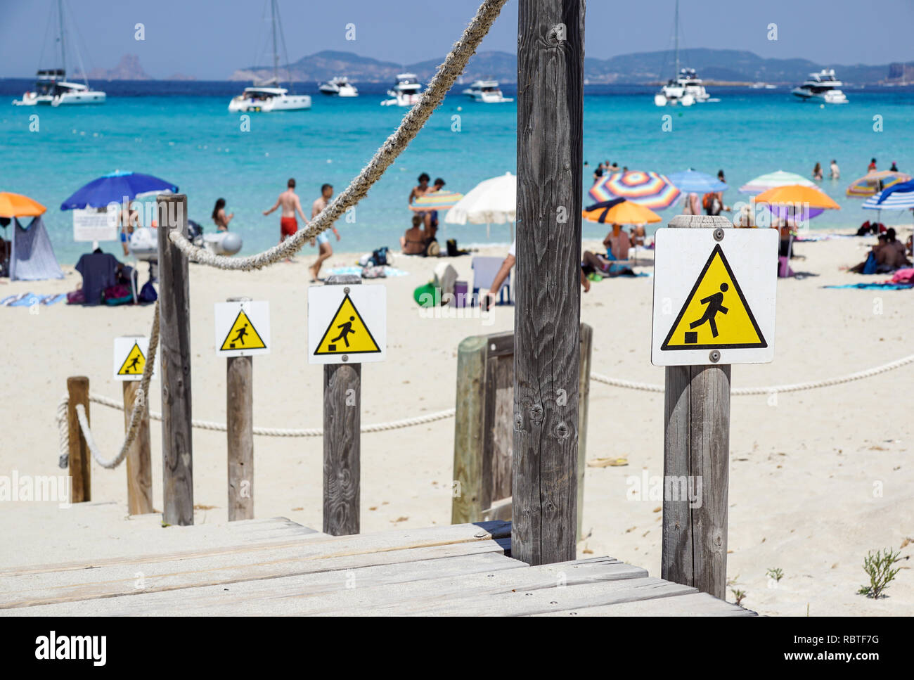 Discesa segno di avvertimento , caduta del bordo triangolo giallo segno sulla spiaggia Foto Stock