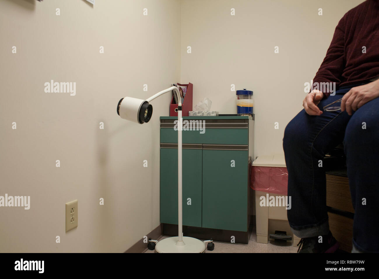 Una donna nella sala esame attende di essere visto dal suo medico. Foto Stock