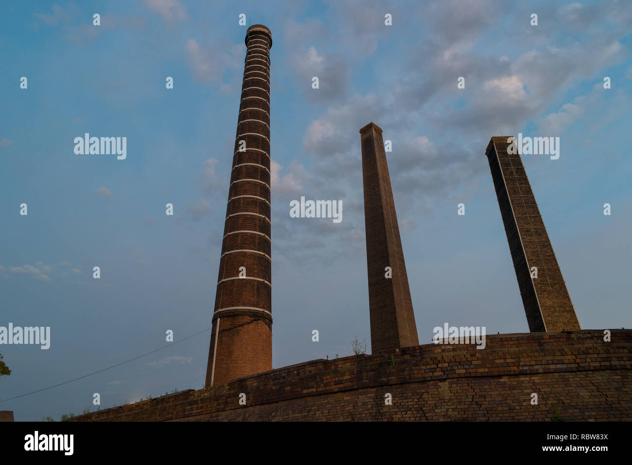 Vecchi camini da un mattone in disuso fabbricante Foto Stock