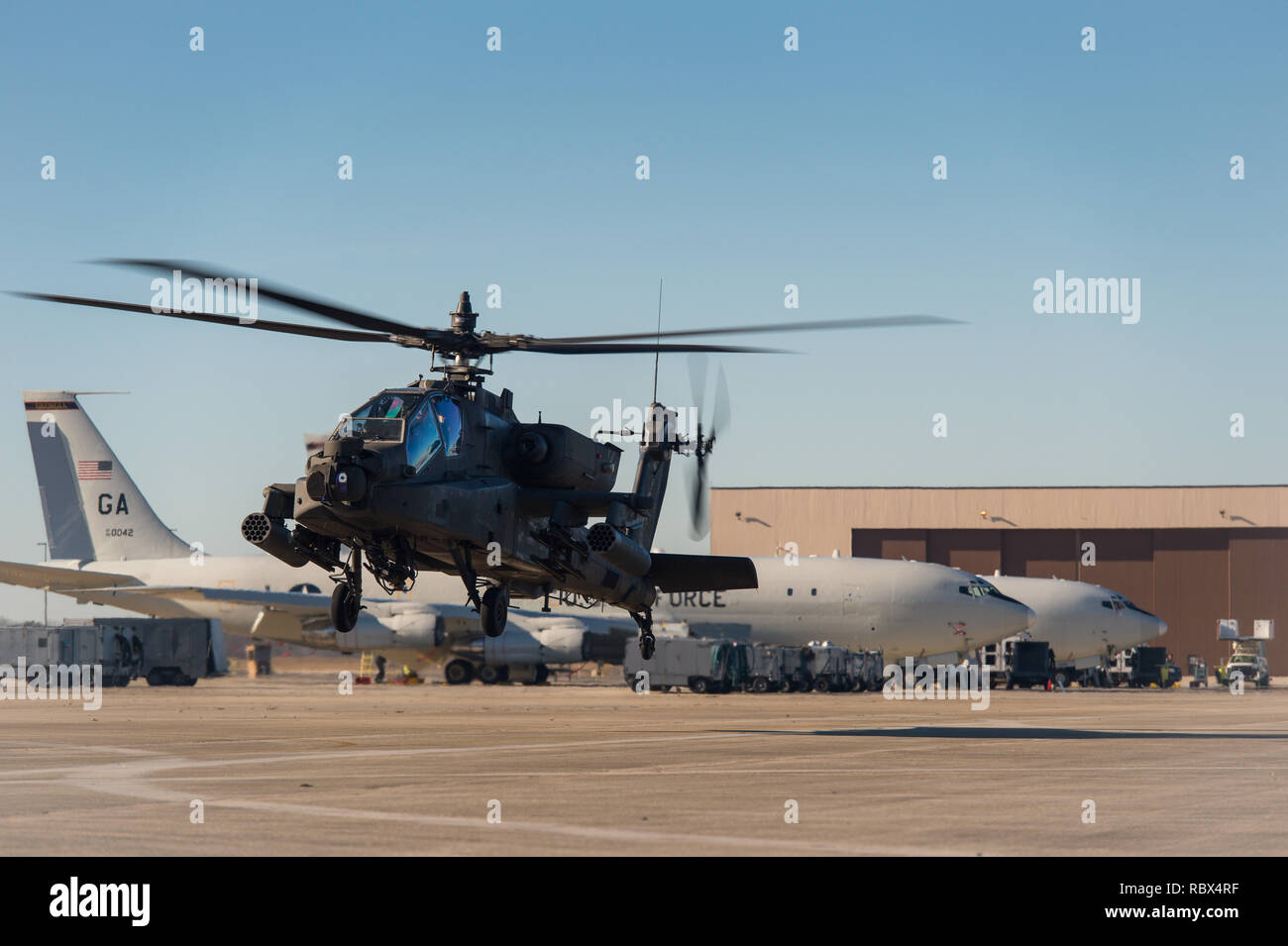 Un AH-64D Apache elicottero vola accanto E-8C comune di stelle aeromobile prima di uscire Robins Air Force Base (AFB), Ga., 10 gennaio, 2019. Stati Uniti Army Chief Warrant Officer 2 William Klinger, pilota al comando, e Chief Warrant Officer 2 Andrew Williamson, pilota, dalla terza divisione di fanteria, 3a combattere la Brigata Aerea, 3/17 reggimento di cavalleria, Hunter Army Airfield, Ga., volò l'elicottero a Robins AFB di soddisfare con soldati e aviatori da Team JSTARS per informarli sulle funzionalità del AH-64D Apache e saperne di più sulle funzionalità del E-8C comune di stelle. (U.S. Air National Guard pho Foto Stock