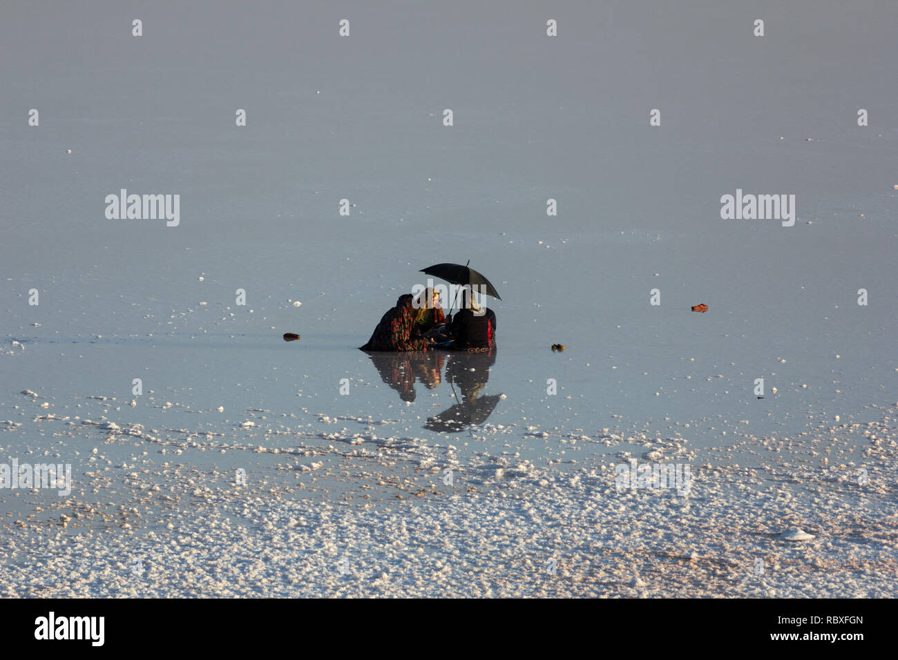 Una famiglia seduta sulla distesa di sale del lago di Urmia, West Azerbaijan provincia, Iran Foto Stock