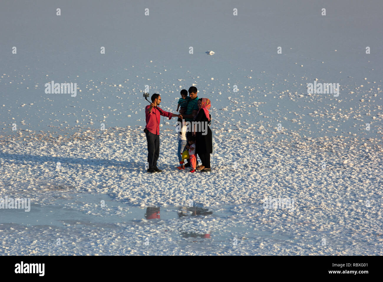 Un uomo è tenuto un selfie foto con la sua famiglia sulla distesa di sale del lago di Urmia, West Azerbaijan provincia, Iran Foto Stock