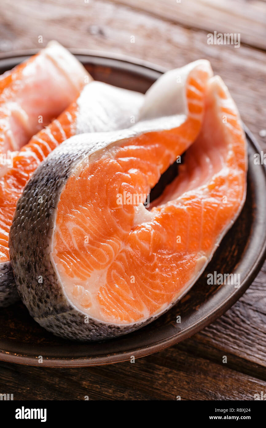 La cottura di due crudo fresco salmone tranci di pesce su legno tavolo rustico closeup Foto Stock