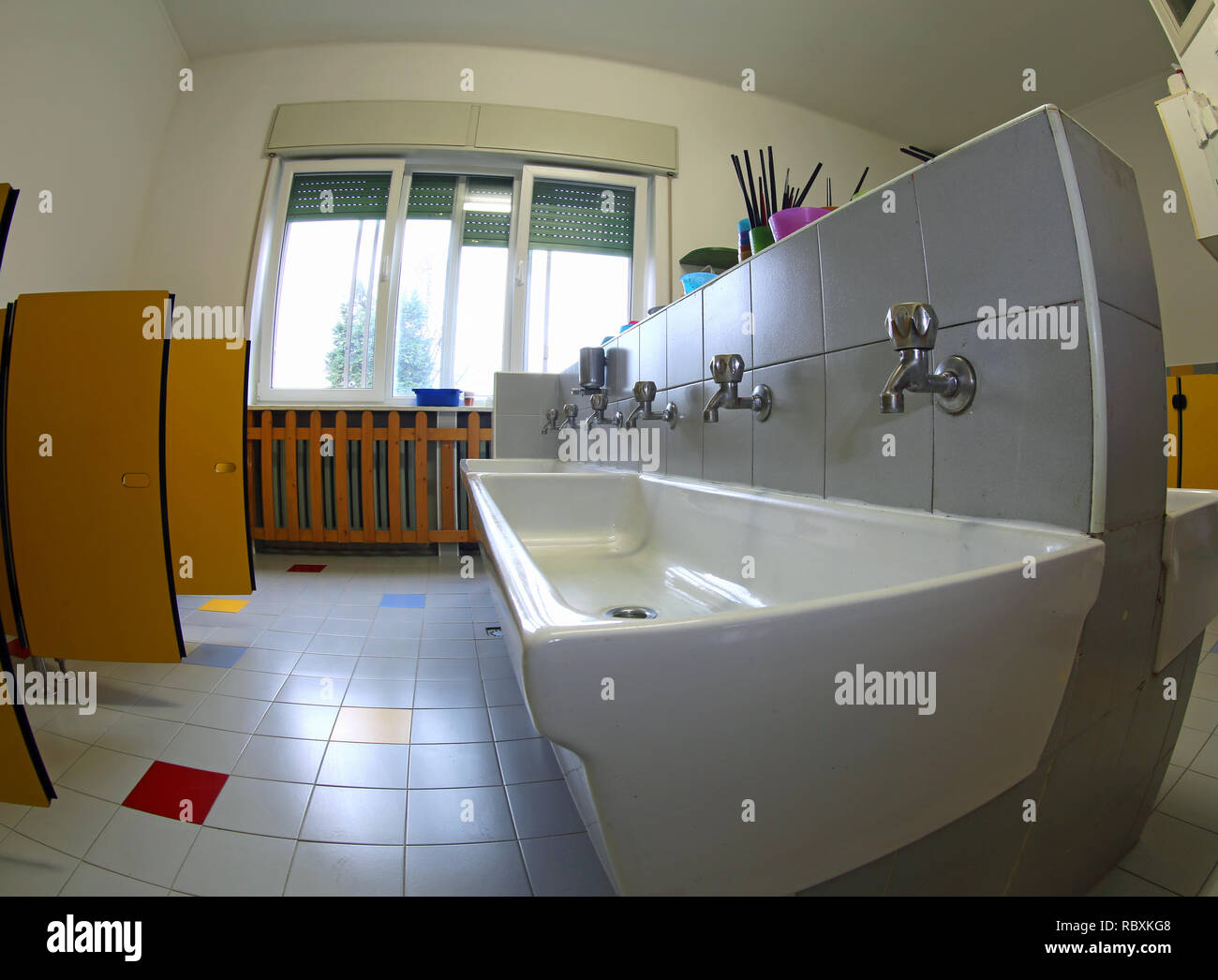 All'interno di una scuola materna grande bagno con lavandini in ceramica Foto Stock