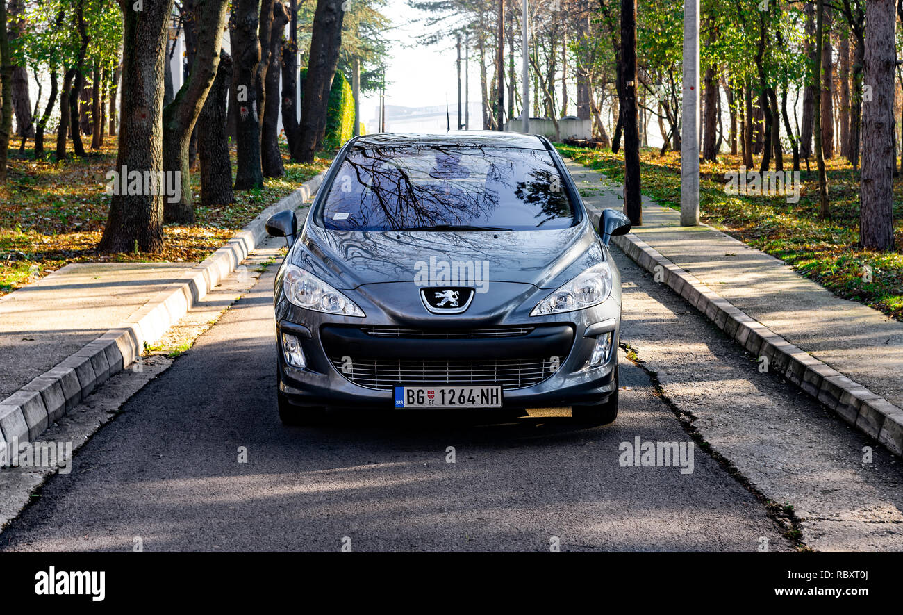 A Belgrado, in Serbia - 11.21.2018 / Peugeot 308 2.0 Hdi, con il colore grigio, parcheggiato sulla strada, in prossimità di alberi con foglie di giallo, grandi ruote in lega. Foto Stock