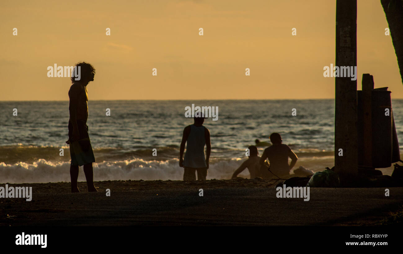 Una foto di una silhouette di un uomo che gode di un bel tramonto in una calda serata estiva Foto Stock