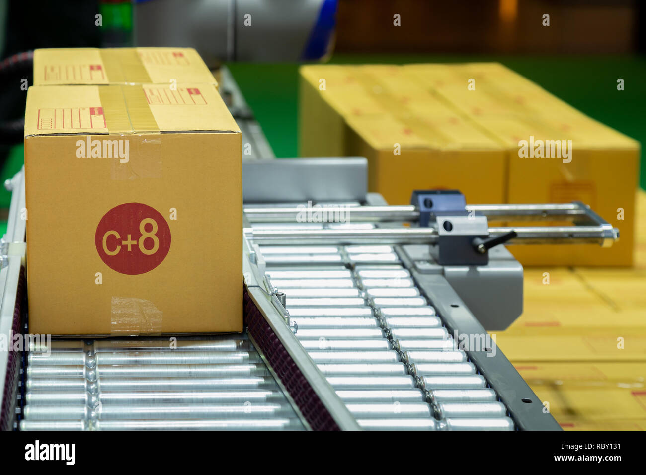 C+8 Dimensioni scatola di cartone di imballaggio del prodotto in movimento sul nastro trasportatore della macchina impacchettatrice automatica nella fabbrica di produzione pronto per la distribuzione t Foto Stock