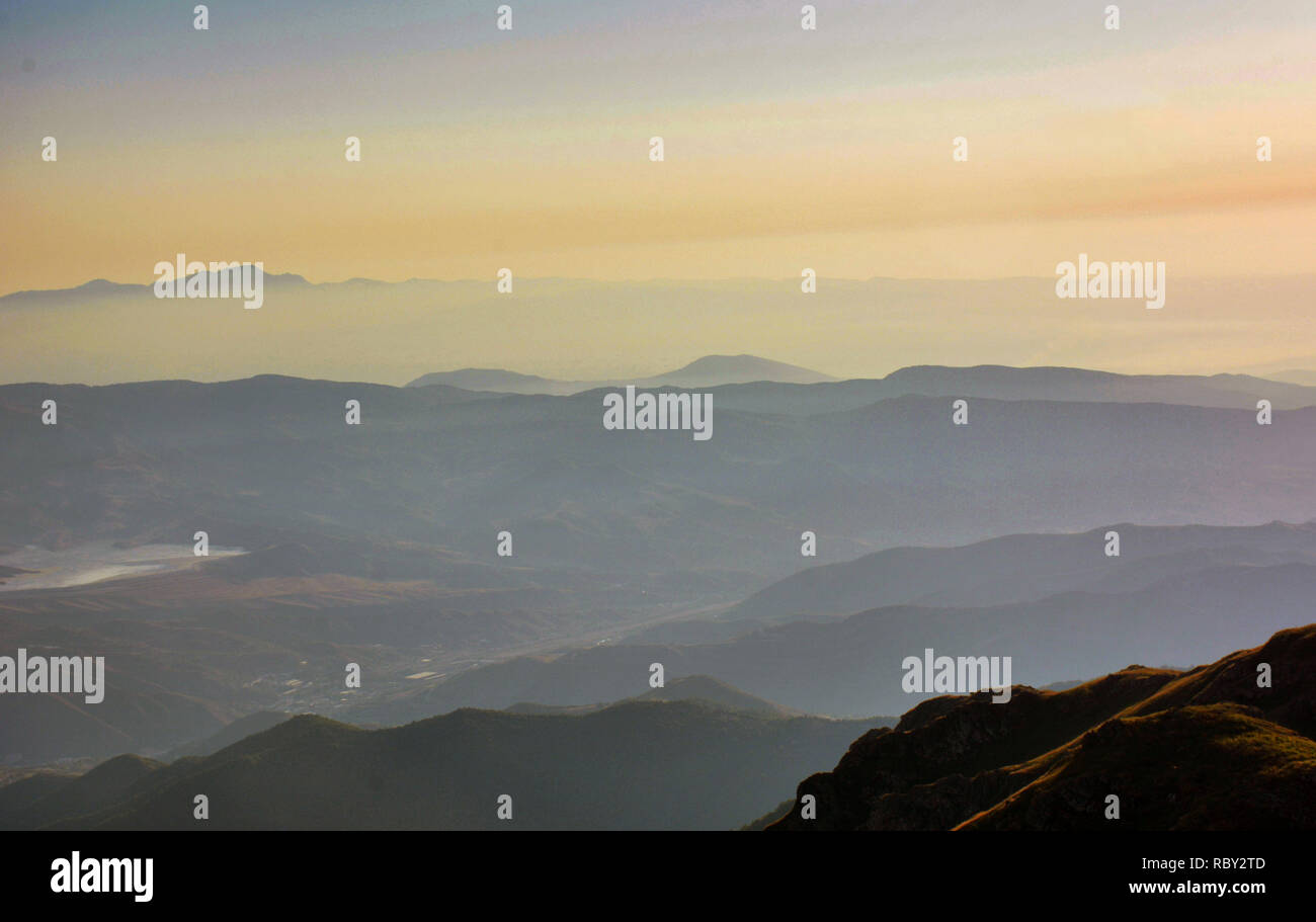 Majestic alba alla montagna. Stordimento e variopinto panorama con il sorgere del sole splende sulle montagne. Catena montuosa al mattino presto. Foto Stock