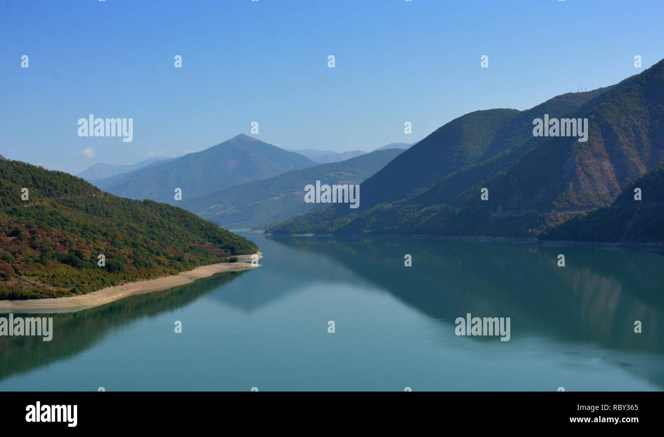 Le montagne circostanti sono riflesse nel lago, bella riflessione. Bellezza Mondo. Jinvali serbatoio acqua, Georgia Foto Stock