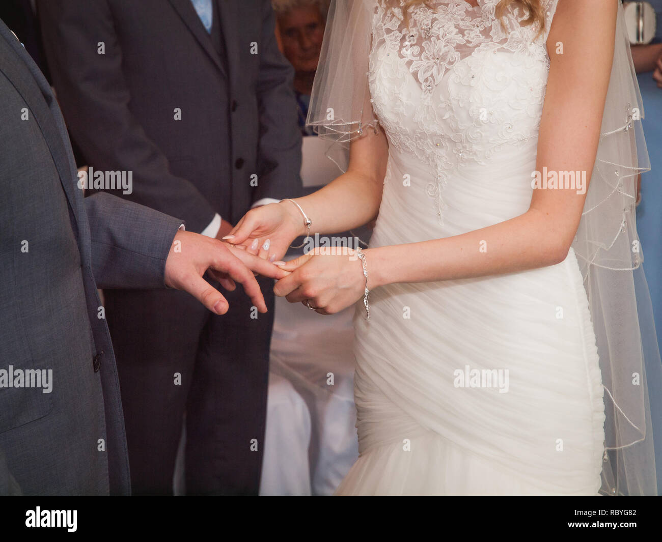 Gli anelli di nozze. Giorno di nozze. Le mani della sposa e lo sposo in solenne processo di scambio di anelli, che simboleggiano la creazione della nuova famiglia felice. Foto Stock