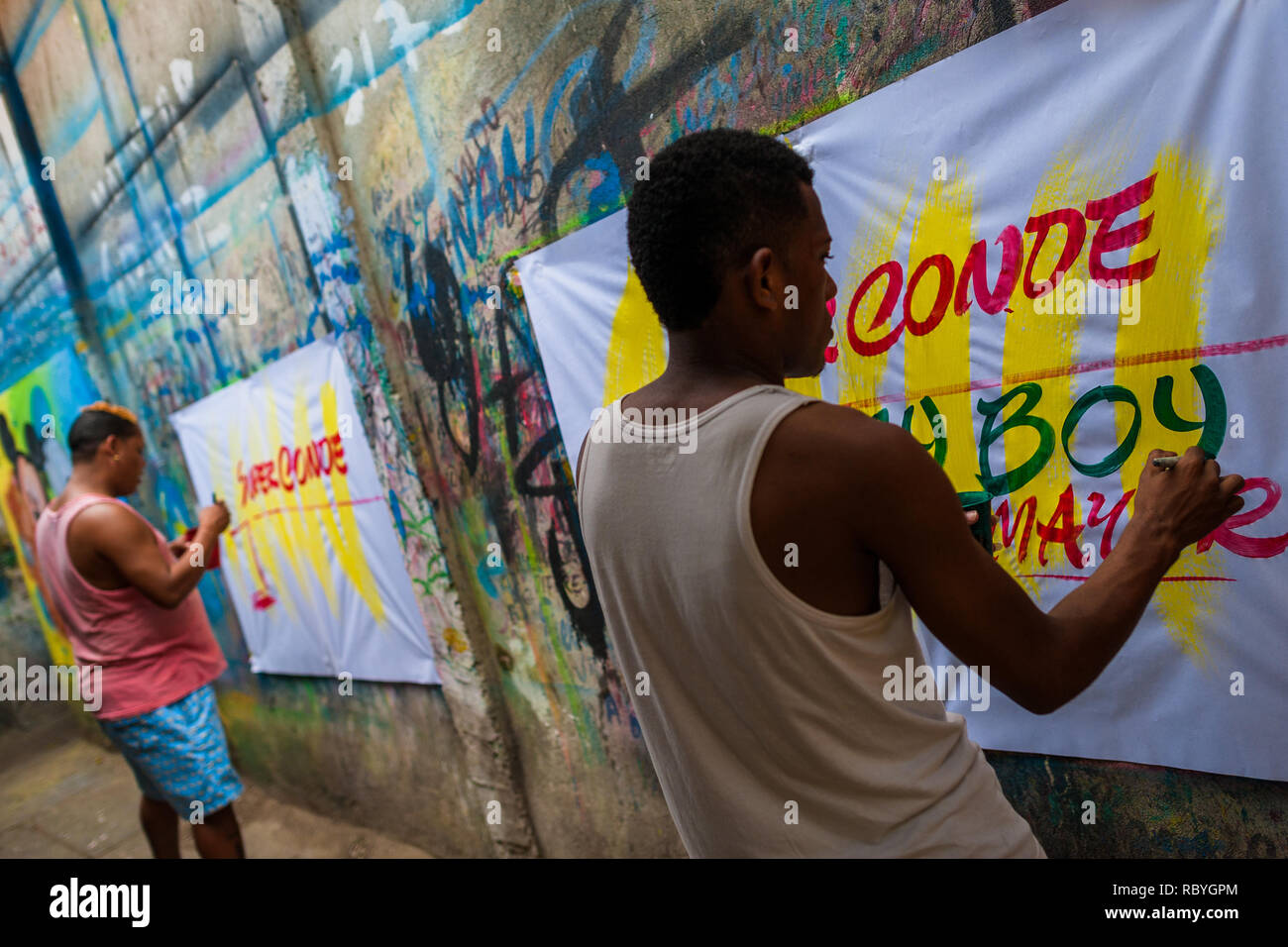 Cartello colombiano pittori scrivere con un pennello mentre si lavora sulla musica poster di partito nel segno atelier di pittura a Cartagena, Colombia. Foto Stock