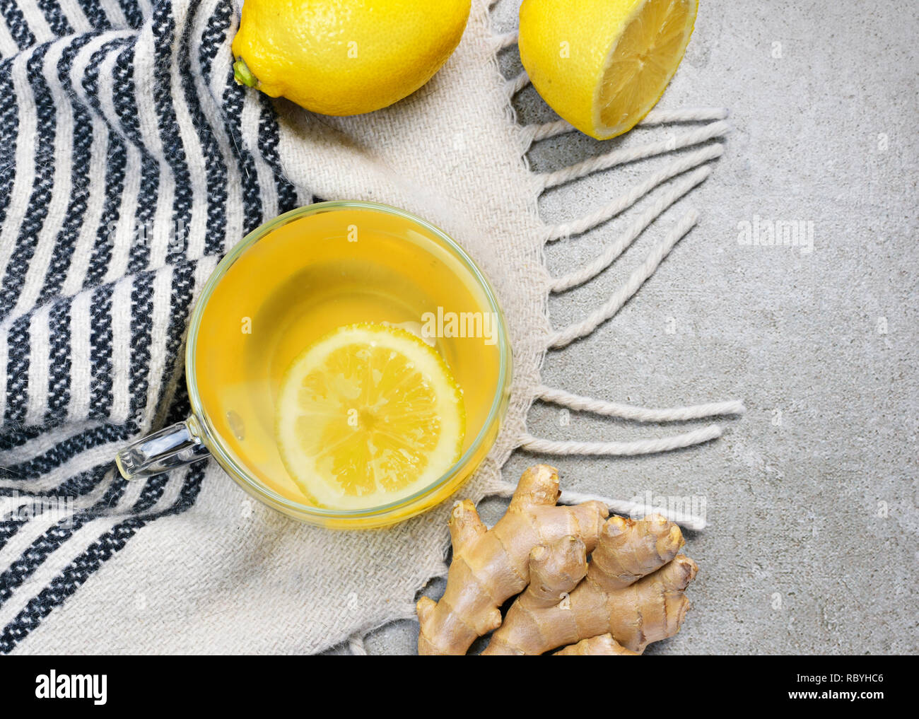 Il tè allo zenzero con fettina di limone e una coppa di vetro. Un sano tea time con zenzero fresco. Scena invernale, vista dall'alto. Foto Stock