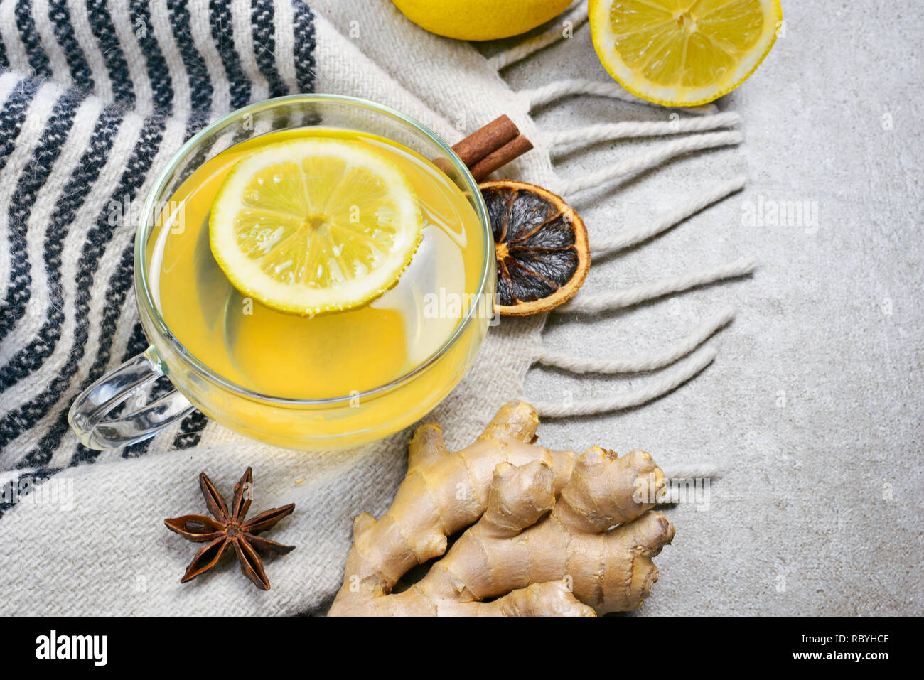 Il tè allo zenzero con fettina di limone e una coppa di vetro. Un sano tea time con zenzero fresco. Scena invernale, vista dall'alto. Foto Stock