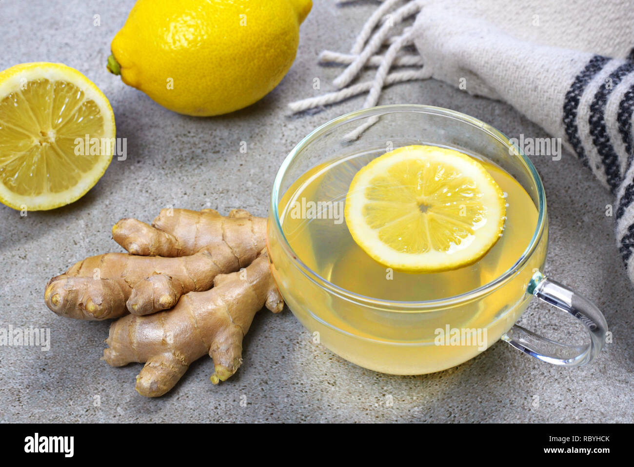 Il tè allo zenzero con fettina di limone e una coppa di vetro. Un sano tea time con zenzero fresco. Scena invernale, vista dall'alto. Foto Stock